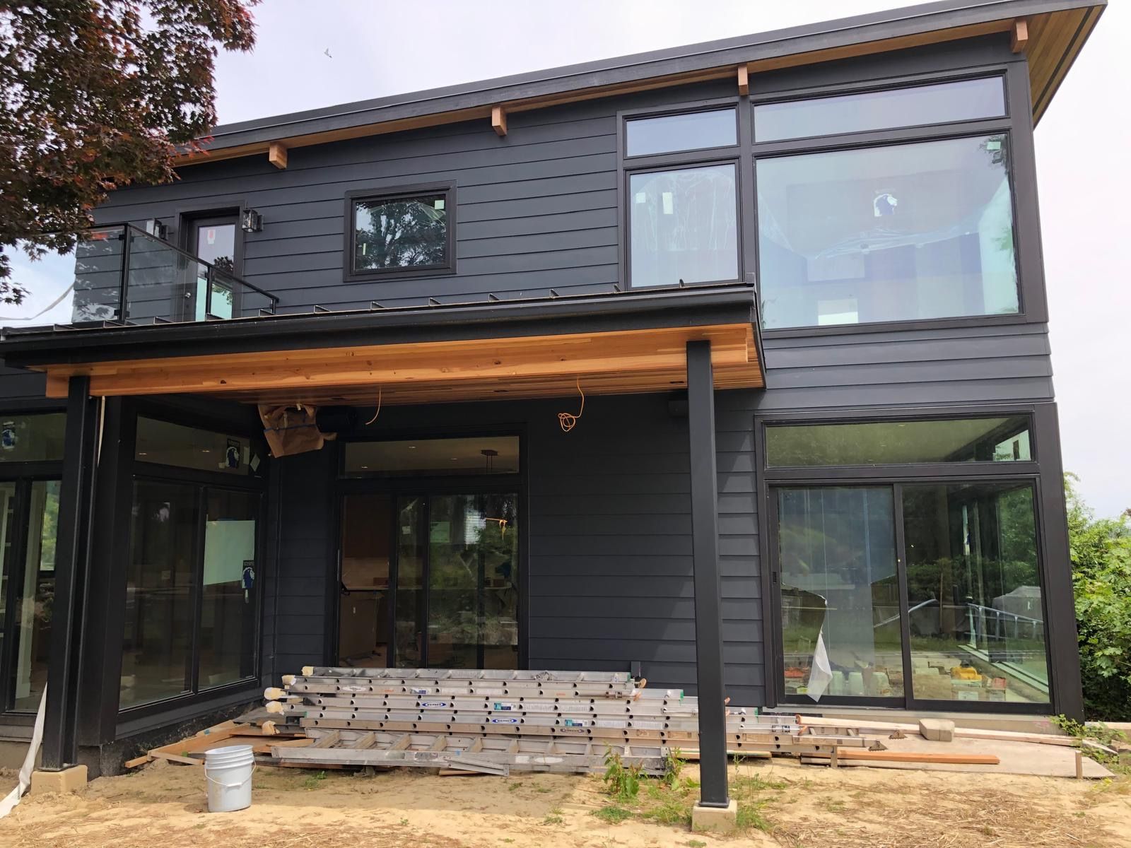Modern home exterior painted deep charcoal with wood soffit accents